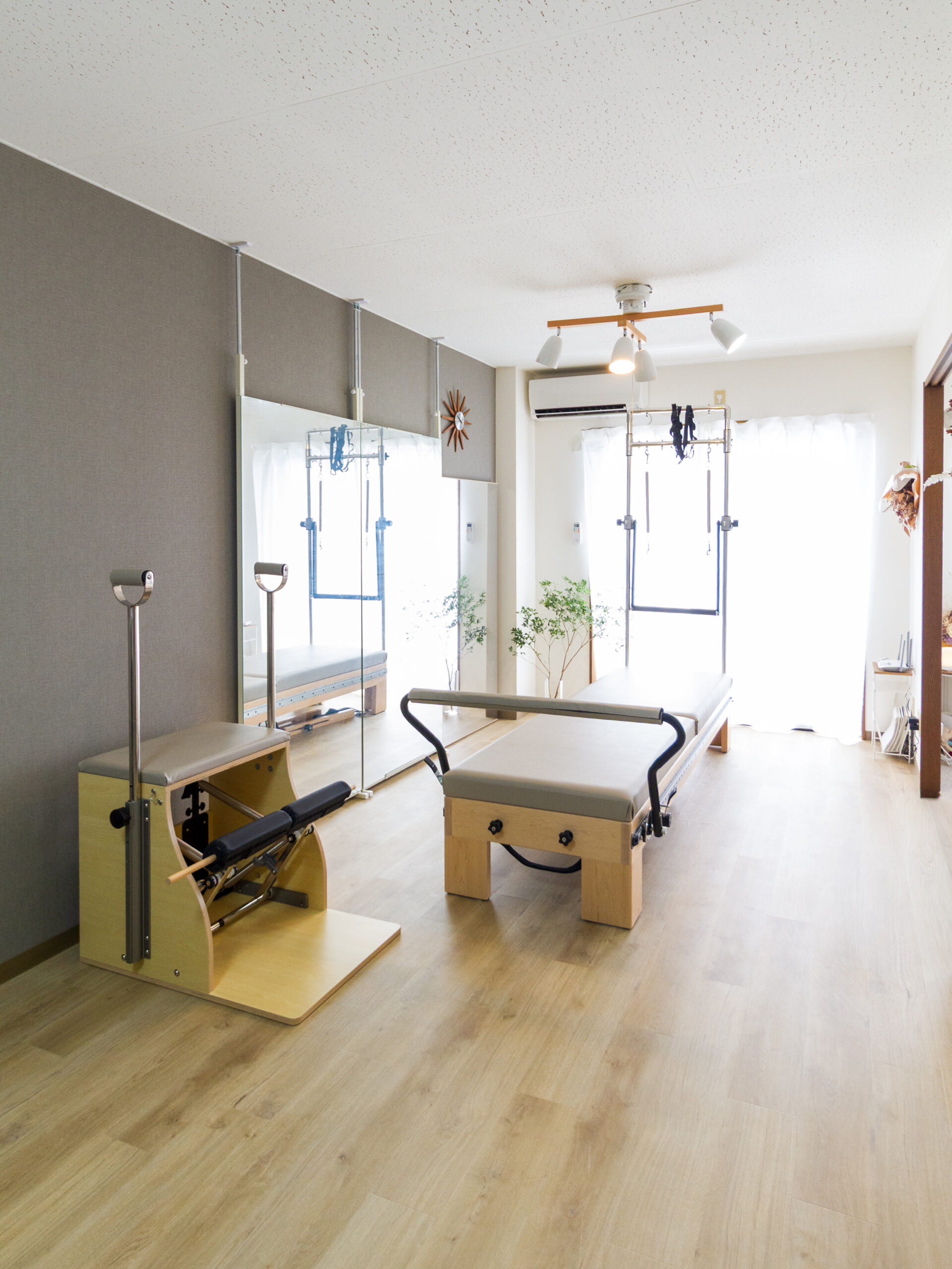 ピラティスマシンが並ぶ、明るいスタジオの様子
