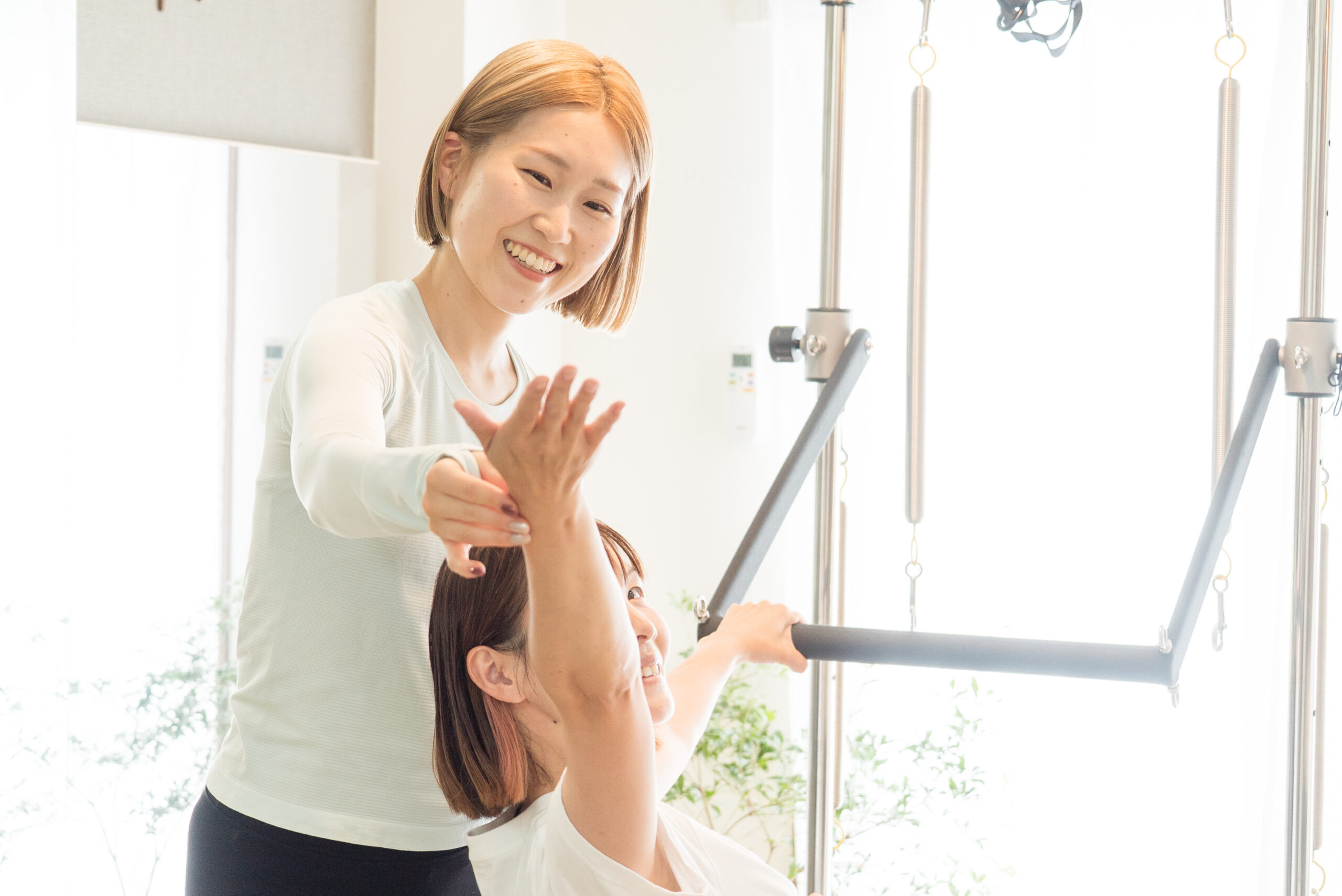 笑顔で声をかけながら、お客さまの腕の動きをサポートするインストラクター